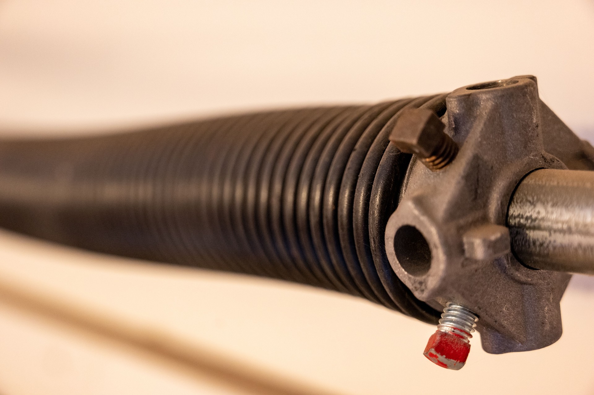 Close up side view of garage door coiled spring